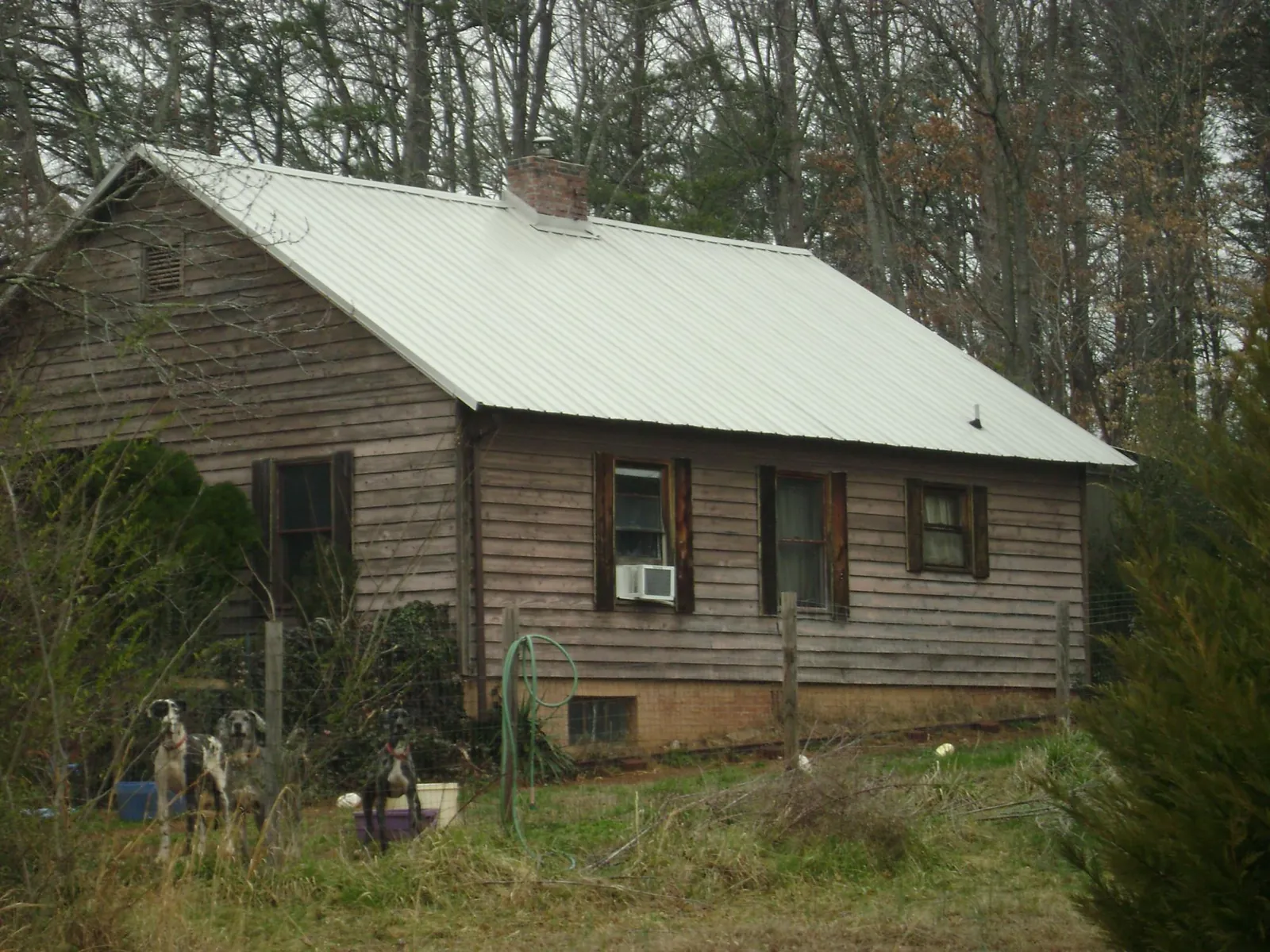 White metal roof on an old wood sided farmhouse, from a Metal Roof Installation job in Summerville